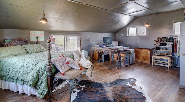 bedroom featuring vaulted ceiling, hardwood / wood-style floors, and wood walls