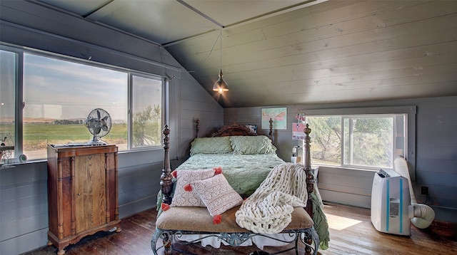 bedroom featuring multiple windows, wood-type flooring, lofted ceiling, and wooden walls