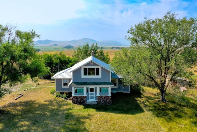 rear view of house featuring a mountain view and a yard