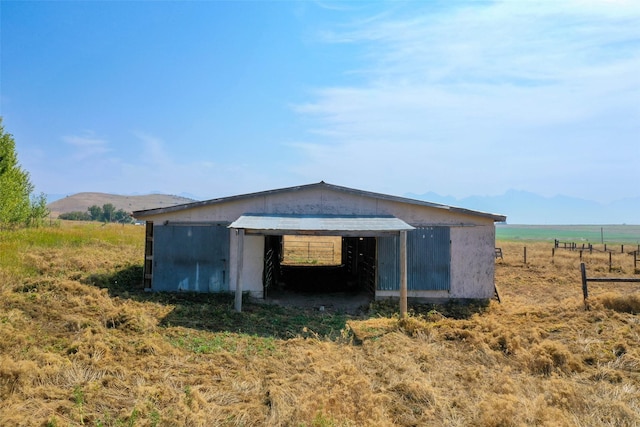 view of outdoor structure with a rural view and a mountain view