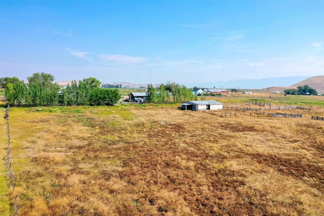 view of yard with a rural view and a mountain view