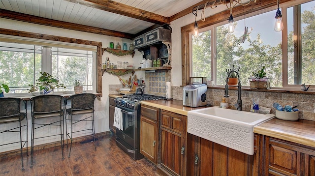 kitchen featuring gas range, wood ceiling, hanging light fixtures, dark hardwood / wood-style floors, and beamed ceiling