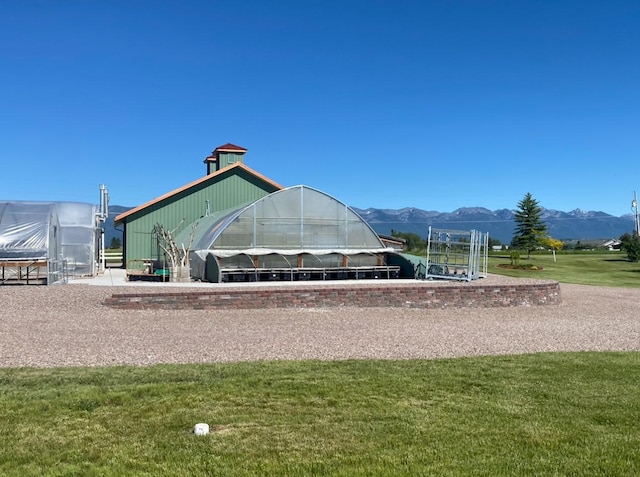 33953 Fox Rd, Polson, MT 59860 - view of community with an exterior structure, a mountain view, an outbuilding, and a yard