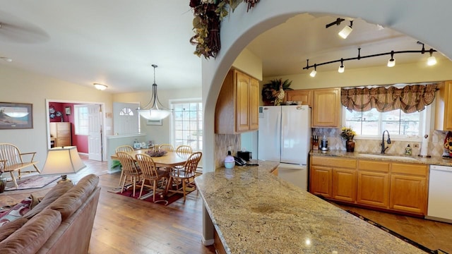 33953 Fox Rd, Polson, MT 59860 - kitchen with white appliances, arched walkways, light stone countertops, backsplash, and vaulted ceiling