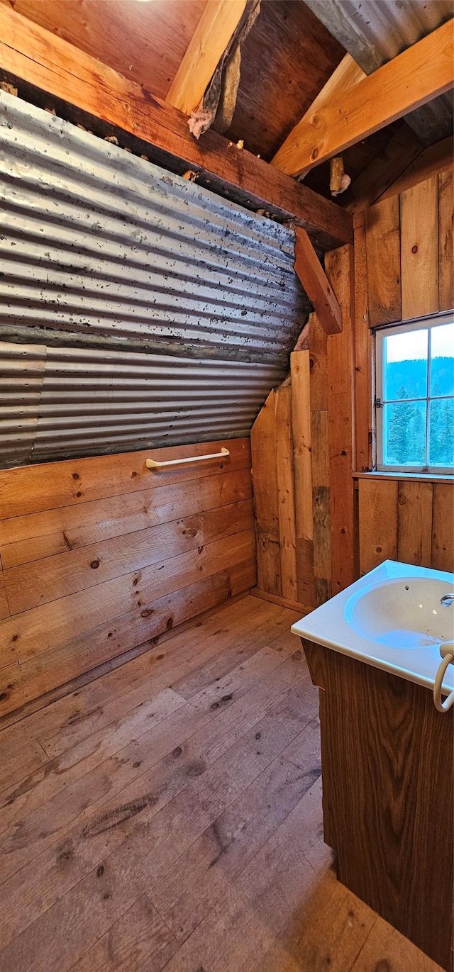 bathroom with wood walls and wood finished floors