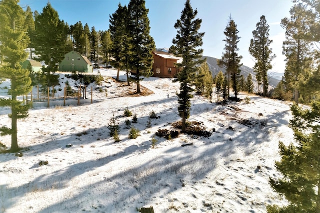 yard covered in snow featuring a mountain view