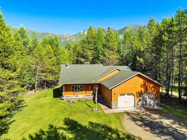 view of front of property with a mountain view, a front lawn, a porch, and a garage