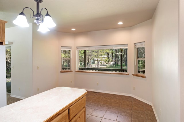 kitchen with tile patterned floors, a notable chandelier, and light brown cabinetry