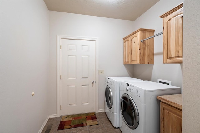 laundry room with washer and clothes dryer, tile patterned flooring, and cabinets