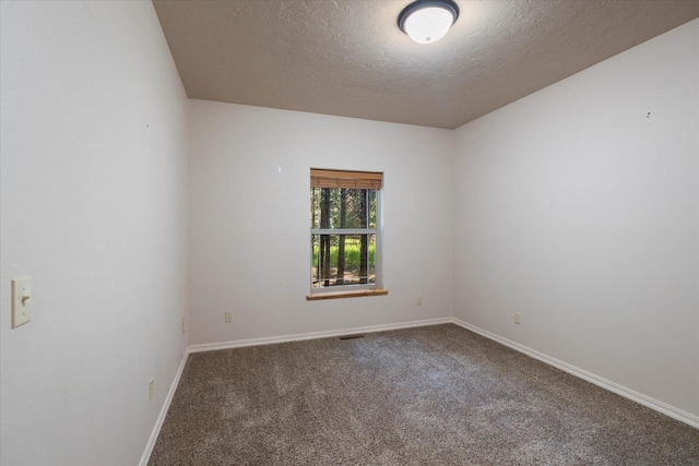 carpeted empty room with a textured ceiling