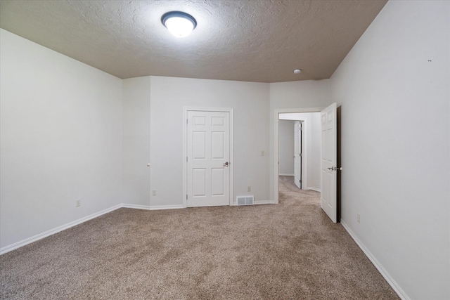 carpeted spare room with a textured ceiling