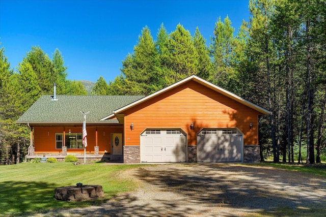 view of front of property featuring a front yard, a porch, and a garage