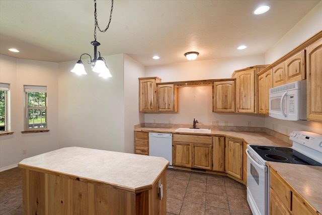 kitchen featuring white appliances, sink, decorative light fixtures, a chandelier, and a center island