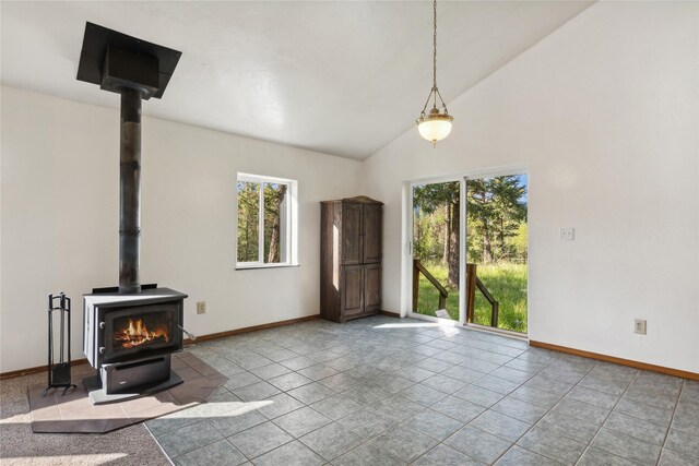 tiled living room featuring lofted ceiling and a wood stove