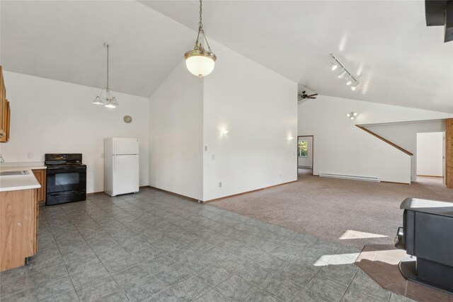 unfurnished living room featuring carpet flooring, a wood stove, sink, a baseboard radiator, and rail lighting