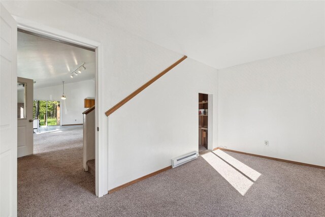 spare room featuring lofted ceiling, carpet, baseboard heating, and rail lighting