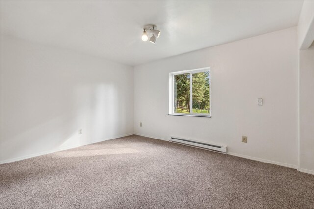 carpeted empty room featuring baseboard heating