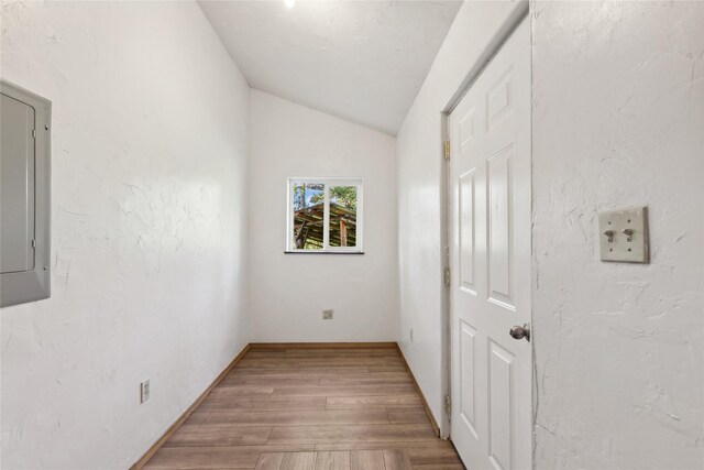 interior space with lofted ceiling, wood-type flooring, and electric panel