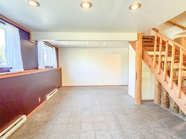 basement featuring baseboard heating and a healthy amount of sunlight