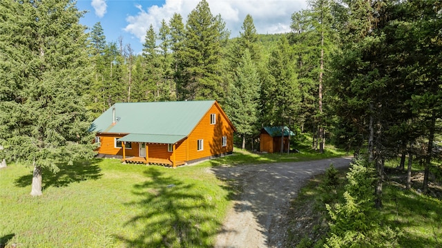 cabin featuring a front yard and a storage unit