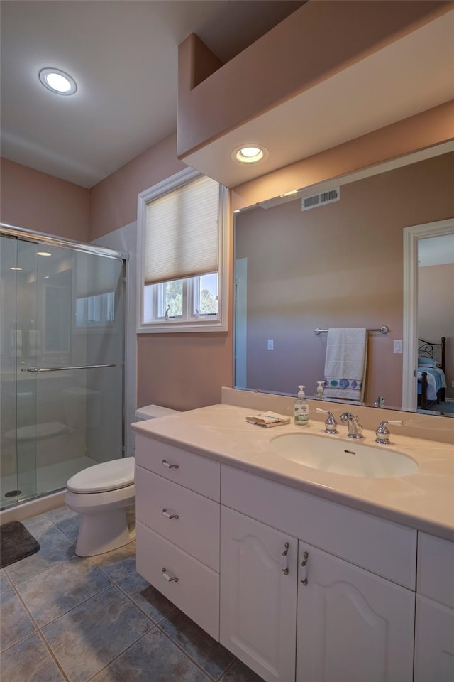 bathroom with vanity, a shower with door, and toilet