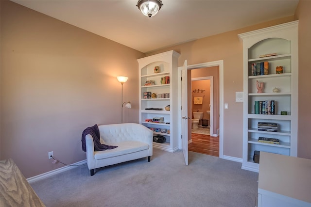 living area featuring carpet and built in shelves