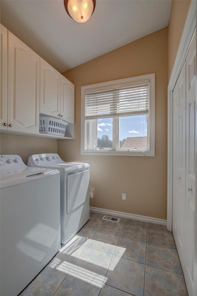 laundry area featuring light tile patterned floors, cabinets, and washing machine and clothes dryer