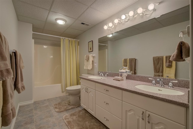 full bathroom with shower / tub combo with curtain, toilet, vanity, tile patterned flooring, and a drop ceiling