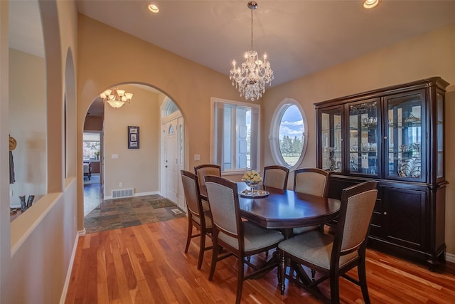 dining area with plenty of natural light, an inviting chandelier, and light hardwood / wood-style flooring