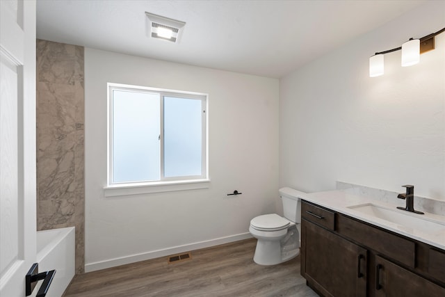 bathroom with hardwood / wood-style floors, vanity, and toilet