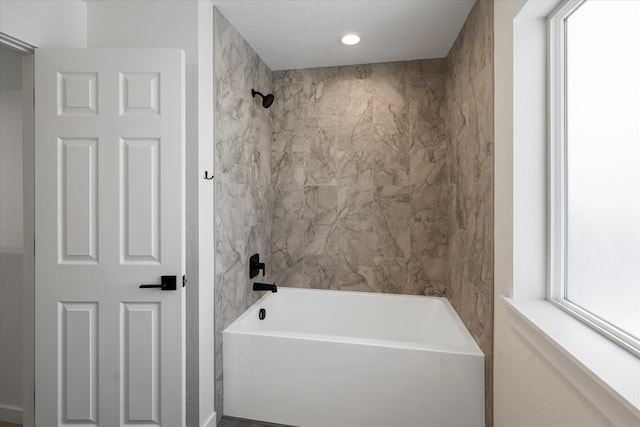 bathroom with plenty of natural light and tiled shower / bath combo