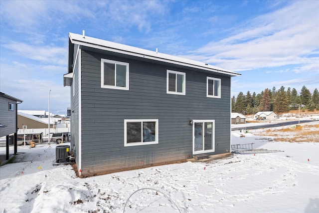 snow covered rear of property with cooling unit