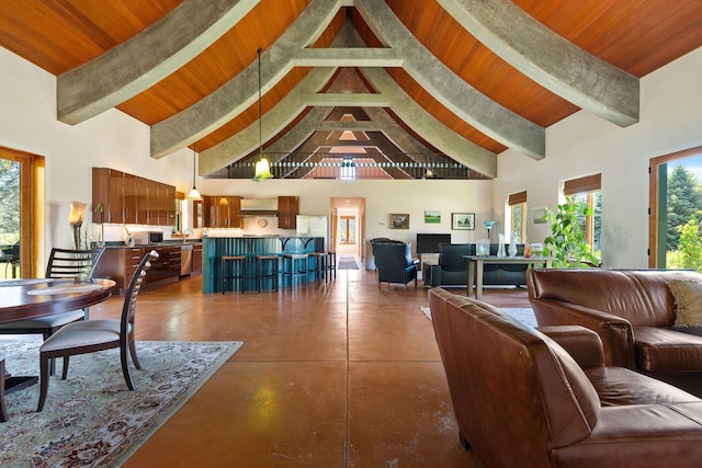 233 Coverdell Rd, Bigfork, MT 59911 - living room with high vaulted ceiling, a wood ceiling with exposed beams, concrete flooring, and plenty of natural light
