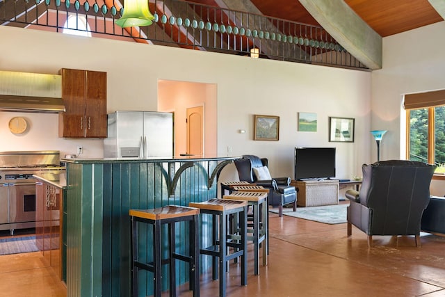 kitchen with wood ceiling, stainless steel appliances, a high ceiling, wall chimney range hood, and concrete flooring