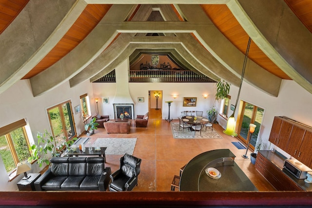 living room featuring high vaulted ceiling, a fireplace, and wood ceiling