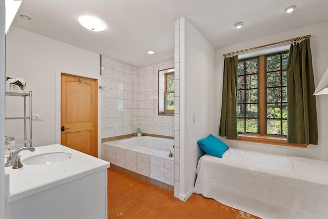 bathroom featuring tiled tub, tile patterned floors, and vanity