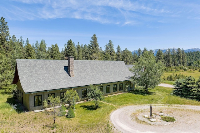 233 Coverdell Rd, Bigfork, MT 59911 - view of front of property with a chimney, a front lawn, and curved driveway