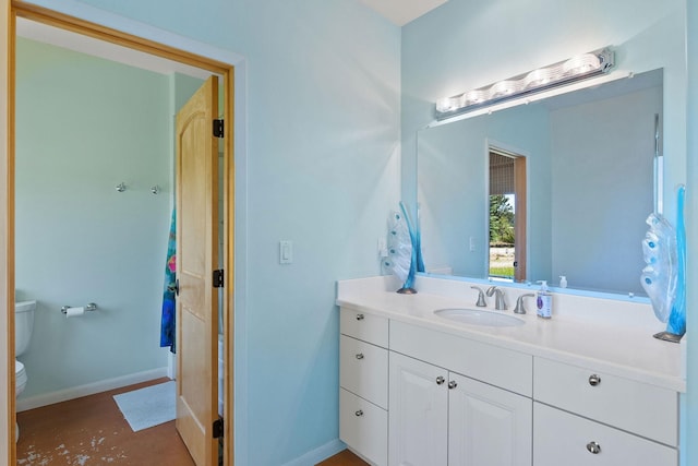 bathroom featuring toilet, vanity, and concrete flooring