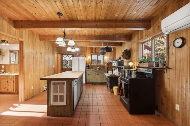 kitchen featuring wood walls, an AC wall unit, freestanding refrigerator, electric range oven, and pendant lighting