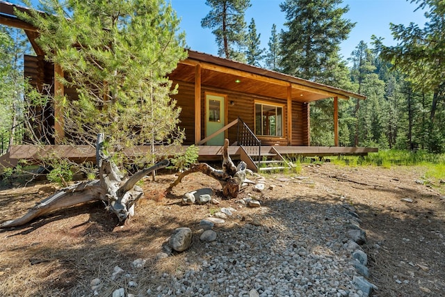 view of front of house featuring log siding and metal roof