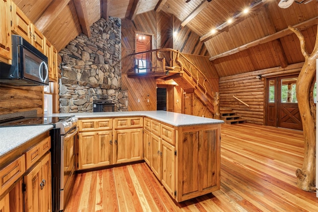 kitchen with stainless steel electric range, light countertops, a peninsula, and light wood finished floors