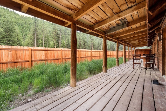 deck with a fenced backyard and outdoor dining area