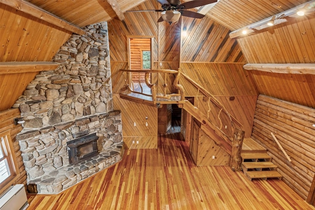 unfurnished living room with a baseboard radiator, lofted ceiling with beams, wood finished floors, and wooden ceiling