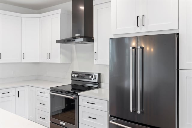 kitchen featuring stainless steel appliances, white cabinetry, and wall chimney exhaust hood