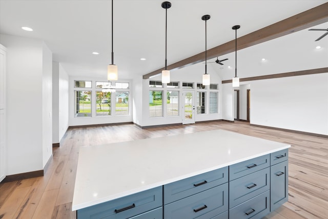 kitchen with light hardwood / wood-style floors, vaulted ceiling with beams, a kitchen island, blue cabinetry, and decorative light fixtures