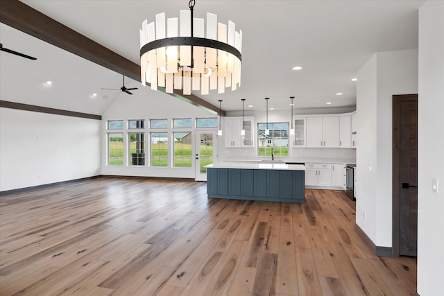 kitchen featuring white cabinetry, a kitchen island, light hardwood / wood-style flooring, beamed ceiling, and pendant lighting