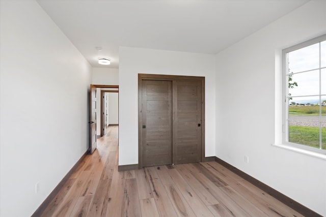 unfurnished bedroom with wood-type flooring and a closet