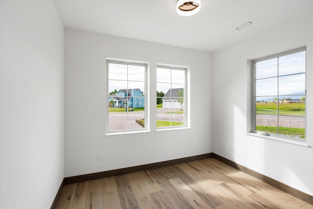 unfurnished room featuring light hardwood / wood-style floors and a wealth of natural light