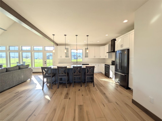 585 Dayton St SE, Ronan, MT 59864 - kitchen with high end fridge, stainless steel range with electric cooktop, wall chimney exhaust hood, light wood-type flooring, and open floor plan