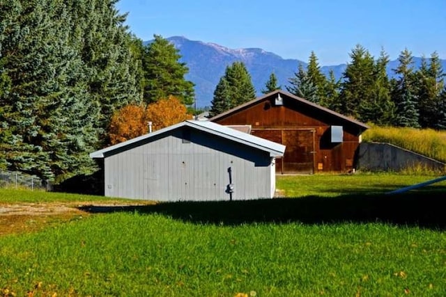 view of outdoor structure featuring a mountain view and a lawn